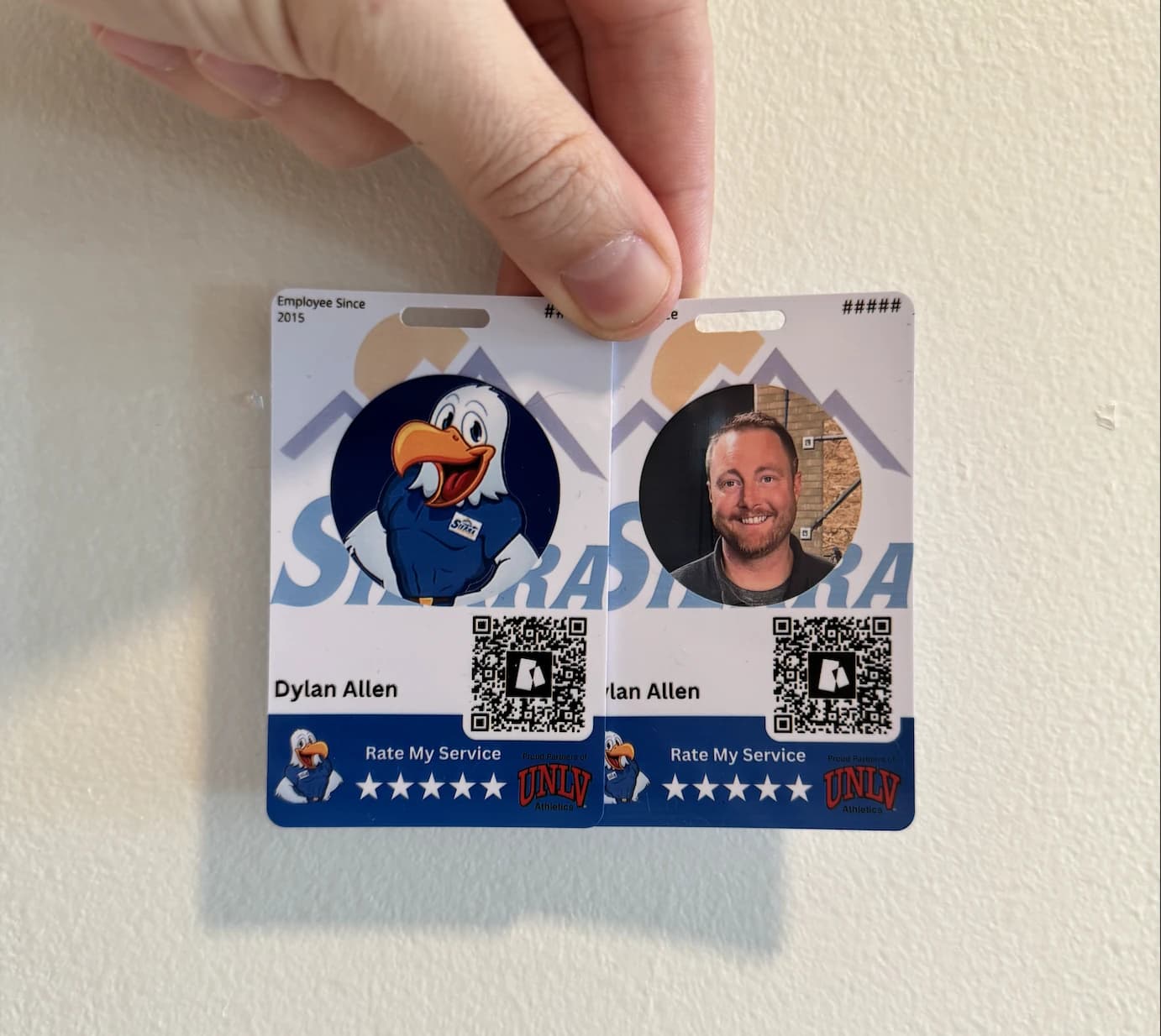 Two physical Cheers prototype badges in a Sierra design, held in a hand